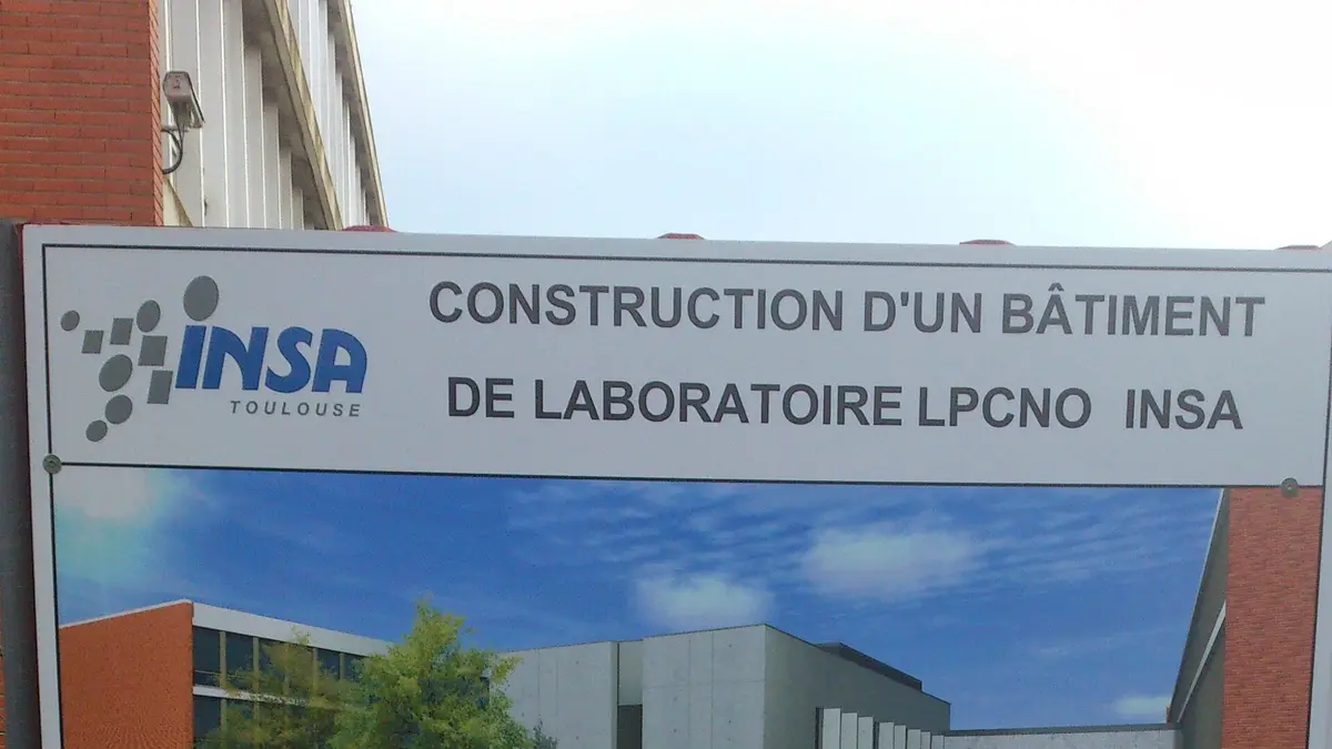 Panneau de chantier indiquant la construction d’un bâtiment, affiché en bordure de terrain